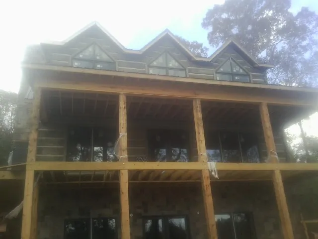 Dormers and porch framing on a large log home under construction — Roof Coating work by our crew in Hastings On Hudson